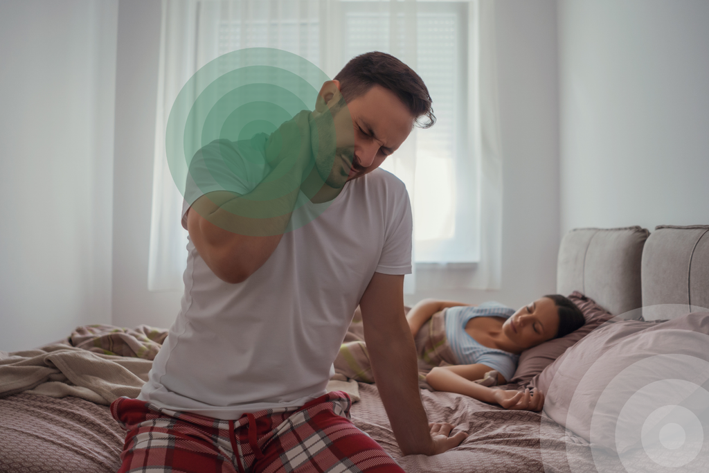 A man waking up with neck pain from sleeping poorly.